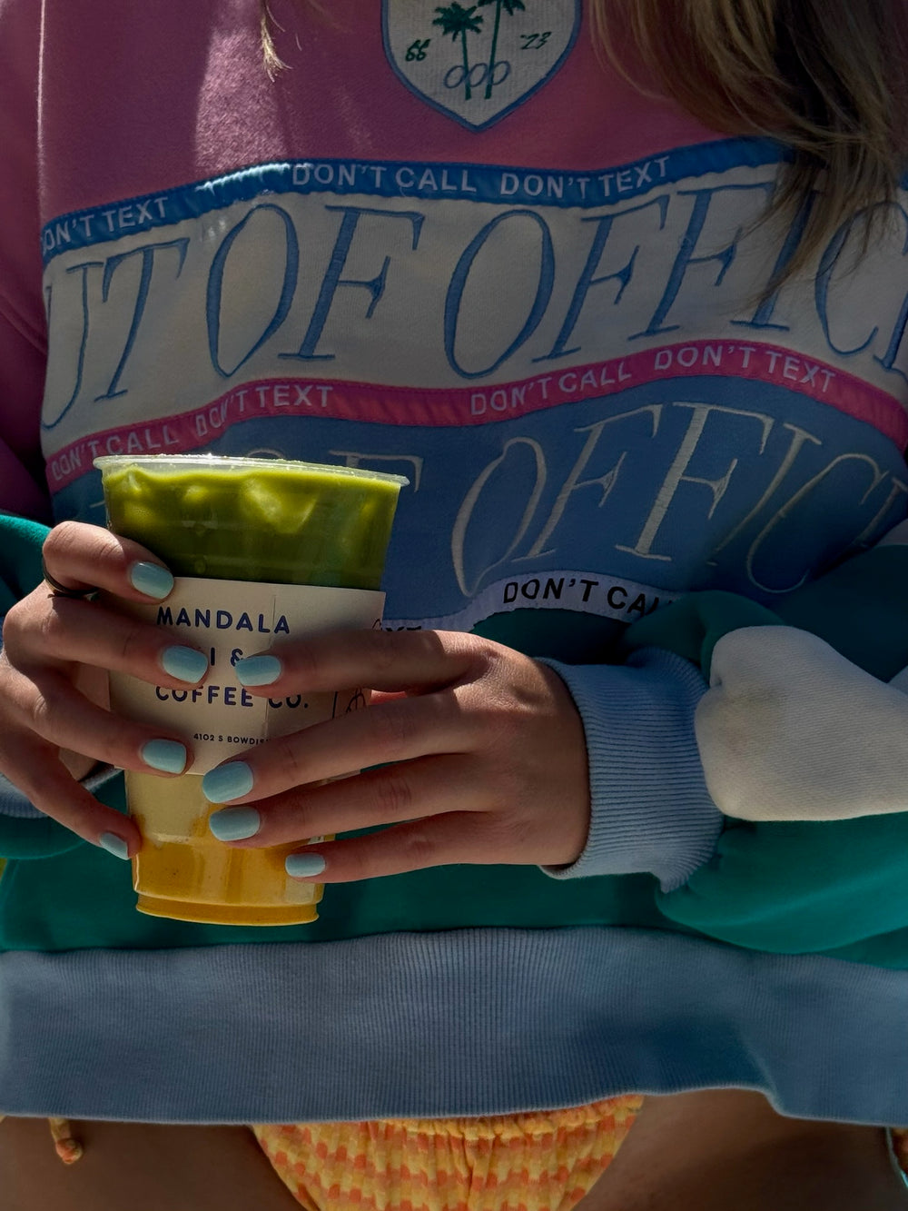 Holding an iced matcha in a Mandala cup sleeve