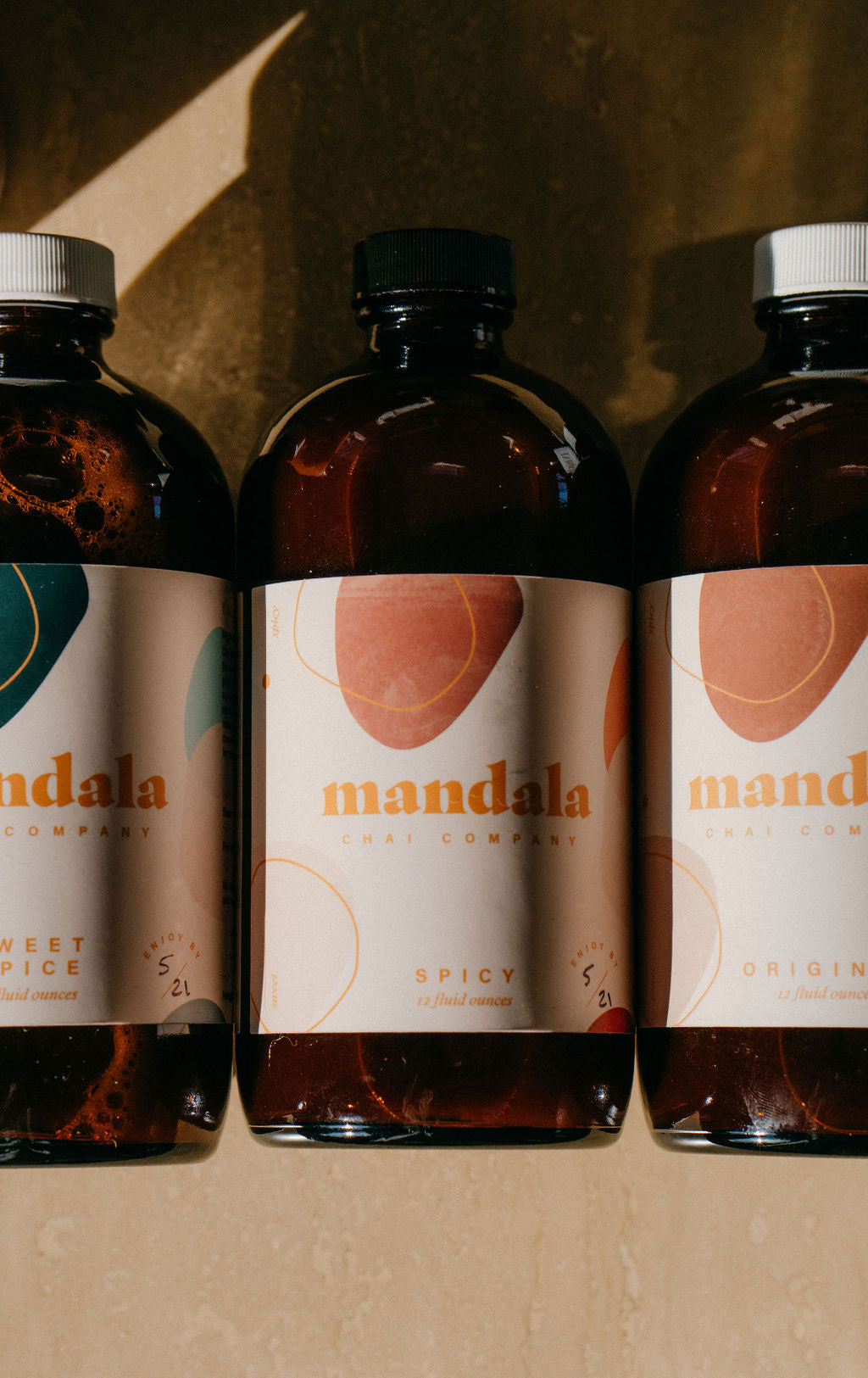 Mandala chai bottles lined up in warm light