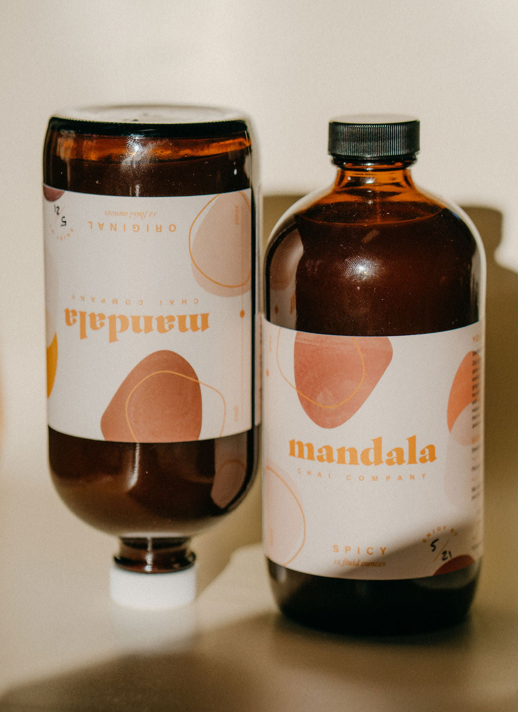 Spicy chai bottle beside an upturned Original bottle