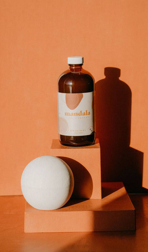 Mandala Original chai concentrate in an amber bottle on a terracotta block